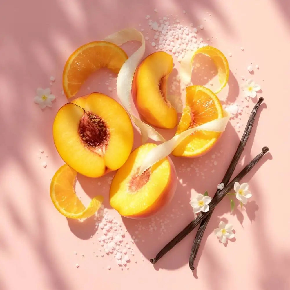 Peach slices with vanilla pods and sugar on a pink background.