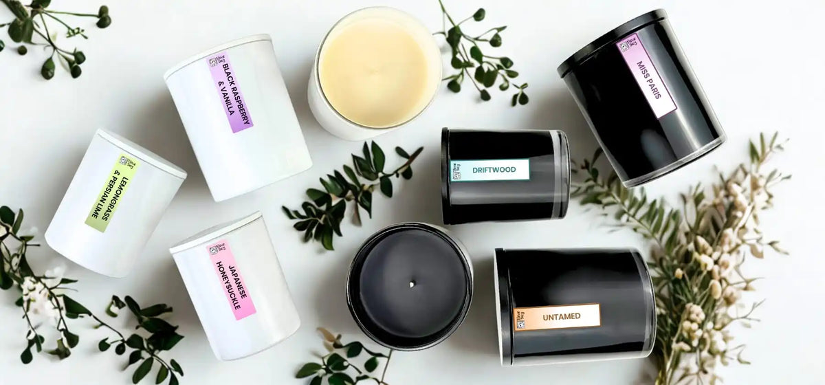 Assortment of scented candles in white and black jars.