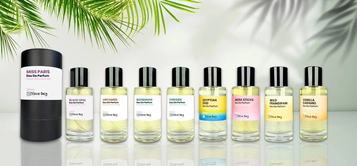 A collection of full and sample-sized perfume bottles with black caps.