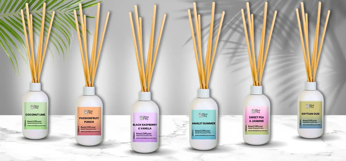Six white bottles of reed diffusers with various colorful labels.